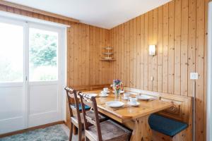 uma sala de jantar com uma mesa de madeira e cadeiras em Apartment im Chalet Speer em Amden