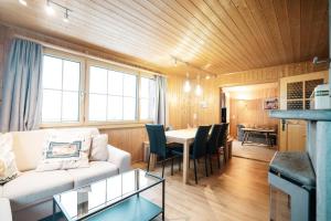 sala de estar con sofá blanco y mesa en Chalet Chapfwald, en Amden