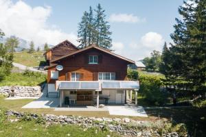 a house on a hill with trees and a yard at Chalet Chapfwald in Amden