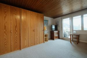 sala de estar con armarios de madera y TV en Apartment Alpenglühen, en Amden