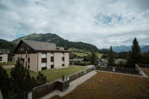 una casa en una colina con montañas en el fondo en Apartment Alpenglühen, en Amden