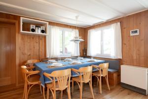 una sala da pranzo con tavolo e sedie blu di Chalet Sönderli ad Amden