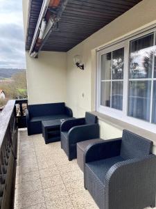 un patio con sofás y sillas en el balcón en Ferienwohnung Antonia, en Rattelsdorf