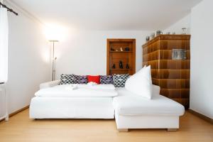 uma sala de estar com um sofá branco e uma mesa em Apartment Raingüetli em Amden