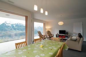 a living room with a table and a large window at Apartment Elona in Amden