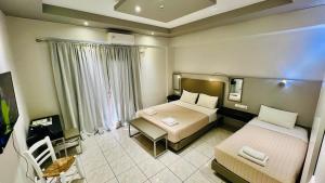 una camera d'albergo con due letti e un tavolo di Atlantis Hotel ad Ágios Nikólaos