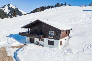 a house on a snow covered hill in the snow at Chalet Theresia in Amden