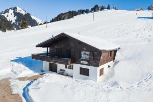 uma casa numa colina coberta de neve na neve em Chalet Theresia em Amden