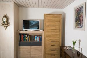 Zimmer mit einem TV und einem Bücherregal in der Unterkunft Apartment Grossgaden in Amden