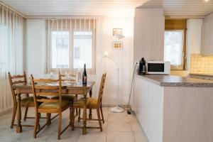 cocina con mesa con sillas y microondas en Apartment Grossgaden, en Amden