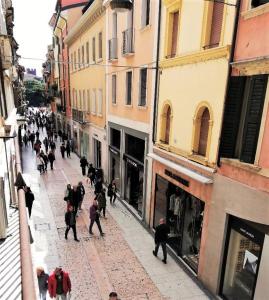 un grupo de personas caminando por una calle en Nicchia, en Verona