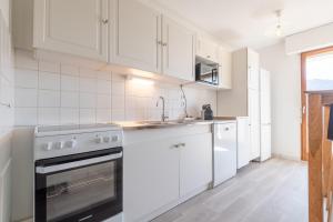 アヌシーにあるDUCS DE SAVOIE - Comfortable flat a stone's throw from the old townの白いキャビネットとコンロ付きオーブンを備えたキッチン +25枚の写真