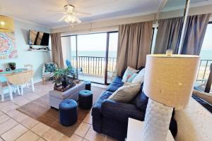 a living room with a blue couch and a view of the ocean at Paradise Found in Carolina Beach +42 photos