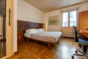 a bedroom with a bed and a desk and a window at Nicchia in Verona