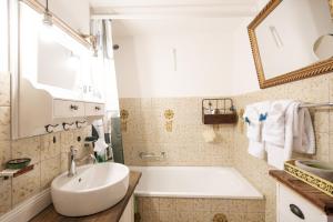 a bathroom with a white tub and a sink at Apartment Mattstogg mit Charme in Amden