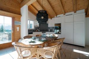 kuchnia z drewnianym sufitem, stołem i krzesłami w obiekcie Apartment zum Leist w mieście Amden
