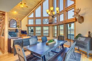 a dining room with a table and chairs and windows at Spacious Stoddard Retreat on Mississippi River! 