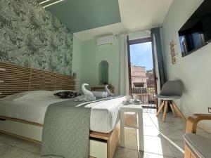 Dolce Marea Suites في ليكاتا: غرفة نوم بسرير ونافذة كبيرة