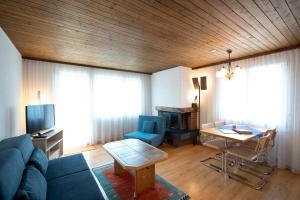 ein Wohnzimmer mit einem blauen Sofa und einem Tisch in der Unterkunft Apartment Bischofberger D22 in Amden