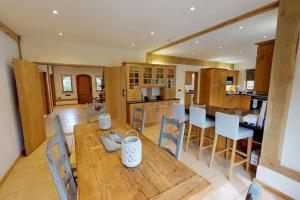 een keuken en eetkamer met een houten tafel en stoelen bij Home in Virginia Water in Wentworth