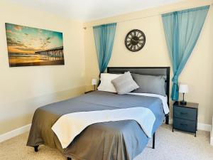 een slaapkamer met een bed met blauwe gordijnen en een klok bij Sopra Bella- 4 bedroom home in Corvallis