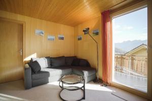 - un salon avec un canapé et une fenêtre dans l'établissement Apartment im Chalet Biodola, à Amden