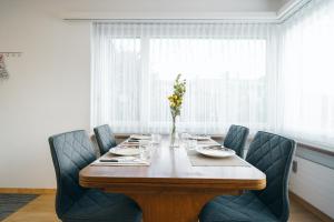 einen Esstisch mit Stühlen und eine Vase aus Blumen in der Unterkunft Apartment Im Aeschen in Amden