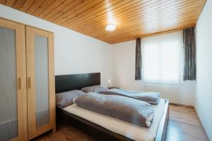 two beds in a bedroom with a wooden ceiling at Apartment Sonne in Amden