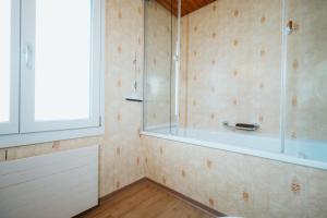 a bathroom with a shower and a tub at Apartment Sonne in Amden