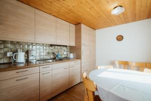 una cocina con armarios de madera y una cama en una habitación en Apartment Sonne, en Amden