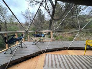 two chairs sitting on a wooden deck in a dome tent at Enchanted Forest Dome ,10-15 minutes to Kings Canyons in Dunlap