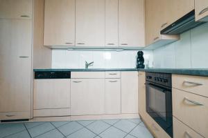 a kitchen with white cabinets and a sink at Schwendihaus Apartment in Amden