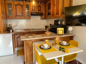 a kitchen with wooden cabinets and a table with yellow chairs at Yellow Home in Santiago de Compostela