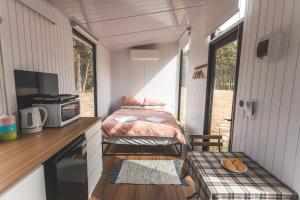 een slaapkamer in een tiny house met een bed bij Pine Edge Heights in Ellendale