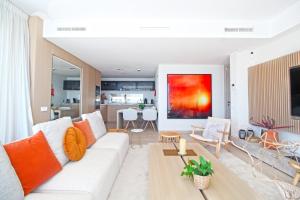 sala de estar con sofá blanco y almohadas de color naranja en Apartment Aria By The Beach en Los Pulpites