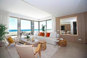 - un salon avec un canapé blanc et quelques fenêtres dans l'établissement Apartment Aria By The Beach, à Los Pulpites