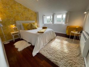 een slaapkamer met een wit bed en een tapijt bij Yellow Home in Santiago de Compostela