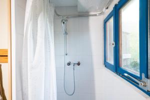 La salle de bains est pourvue d'une douche et d'une fenêtre. dans l'établissement Cottage Obereichholzberg, à Weesen