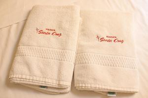 duas toalhas sentadas uma ao lado da outra numa cama em Pousada Santa Cruz em Aparecida