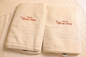 two towels sitting next to each other on a bed at Pousada Santa Cruz in Aparecida