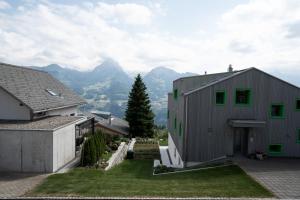 ein Haus mit grünen Fenstern an der Seite in der Unterkunft Haus Gmür Amden Erdgeschoss in Amden