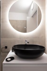 een badkamer met een zwarte wastafel en een spiegel bij Lucana Rooftop in Matera