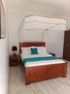 1 dormitorio con 1 cama con dosel en Beri Cottages, en Arua