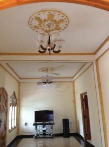 a living room with a chandelier and a tv at 'Villa'chava in Chavakachcheri