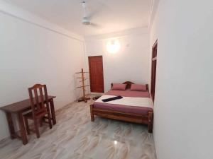 a bedroom with a bed and a chair in it at 'Villa'chava in Chavakachcheri