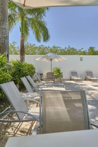 a group of chairs and umbrellas on a patio at Elegante Aqua Marine Apartamento en Playa Juan Dol in Juan Dolio