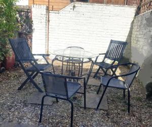 a group of chairs and a table in a yard at Willow House Excellent accomodation Central Exeter-Uni-Chiefs-RD&E-Courtyard Garden-Parking-Sleeps up to 6 in Exeter