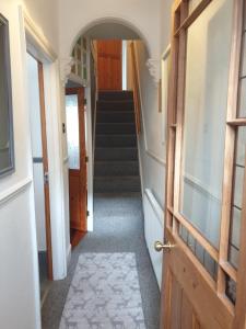a hallway with a door and a stairway at Willow House Excellent accomodation Central Exeter-Uni-Chiefs-RD&E-Courtyard Garden-Parking-Sleeps up to 6 in Exeter