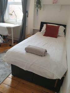 - un grand lit blanc avec une serviette dans l'établissement Willow House Excellent accomodation Central Exeter-Uni-Chiefs-RD&E-Courtyard Garden-Parking-Sleeps up to 6, à Exeter