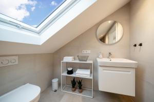 a bathroom with a sink and a skylight at Apartment Milse - Modern. Stylisch in Bielefeld +20 photos